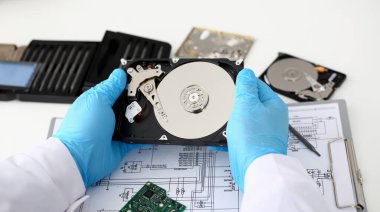 Mavi eldiven giymiş bir erkek tamirci bilgisayarınız veya dizüstü bilgisayarınız bir sabit diskten elinde tutuyor. Hata tanılama gerçekleştirir ve acil onarım kurtarma kayıp veri silme Hdd closeup sırasında gerçekleştirir