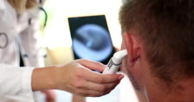Otolaryngologist examines patient ear with digital otoscope. Hearing test and ear inflammation treatment