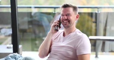 Happy joyful man is talking on the phone with girlfriend or business partner. Emotions of successful guy speaks on smartphone