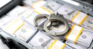 Open suitcase with stack of million dollars and handcuffs. Bribe arrest and detention of a diplomat