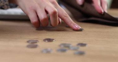 Woman hand counts coins on table closeup. Financial problems crisis and inflation and poverty