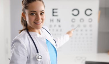 Kadın doktor klinikteki masayı kullanarak görme yeteneğini kontrol ediyor. Vizyon düzeltme kavramı