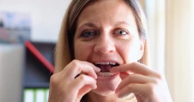 Kadın diş ısırığını düzenlemek için plastik diş kapağı takıyor. Yetişkin kavramında ısırığı düzeltmek için büyük harf