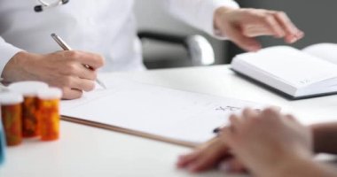 Doktor ilaç için reçete yazıyor ve pul yapıştırıyor. Yazılı tıbbi ürün reçetesi