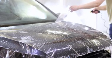 Araba servisindeki araba kaputuna koruyucu film uygula. Çevirmeli silindirli araba korunuyor.