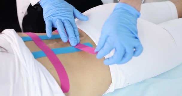 Dokter Lijmt Kinesio Tape Aan Ruggengraat Van Patiënt Rugstretch Behandelingsconcept — Stockvideo