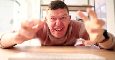 Bilgisayar klavyesinde yazı yazan ve internete 4K film yavaş çekim şikayeti yazan kızgın bir adam. İnternet dolandırıcılığı kavramı