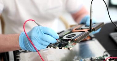 Usta tamirci ana kartı onarmak için 4K film yavaş çekimde test cihazı kullanıyor. Elektronik tamir ve bakım konsepti
