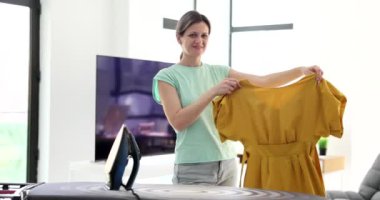 4K film ağır çekimde sarı elbiseli bir kadın. Ev rutini kavramı