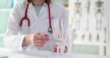 Doktor romatolog insan elinin yapısını anatomik model yakın çekim 4K yavaş çekim filminde gösteriyor. Kol romatizma hastalığı konsepti patolojisi