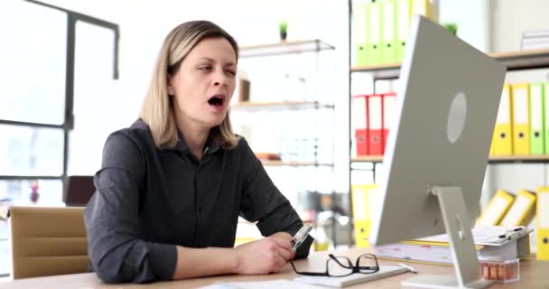 ビジネスマンの女性がコンピュータでテーブルに座って 4K映画スローモーションをあくびをします 不眠症と退屈な仕事の概念 — ストック動画