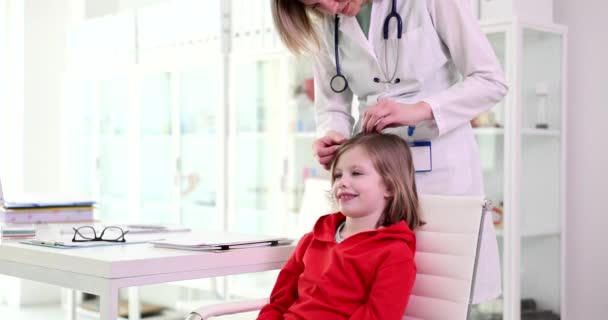 小児科医は 診療所4K映画スローモーションで子供の頭と髪を検討 小児科およびミクロスポリアの概念の診断と治療 — ストック動画
