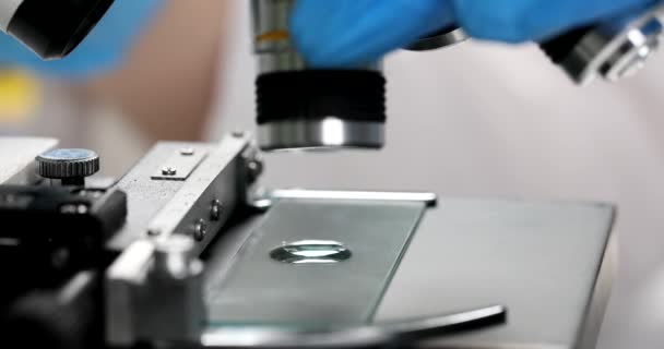 化学家科学家在显微镜下仔细观察4K膜慢动作下观察玻璃滑块上的液滴 制药企业概念 — 图库视频影像