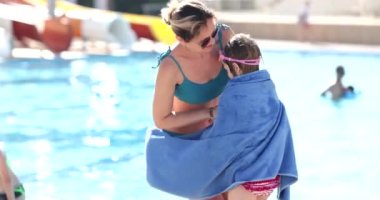 Havuza sarılı mutlu anne ve kız çocuğu. Anne banyodan sonra bebeğe sarıldı.