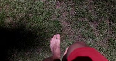 İnsan ayağı yeşil yaz çimlerinde yürür. Yaz zamanı ve çimenlerde yalın ayak yürümek