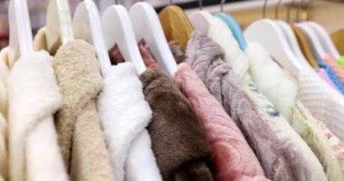 Terry bornozları mağazada asılı duruyor. Bornozlar farklı renklerde bulunur. Dükkanda asılı dururlar.