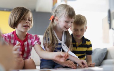 Portrait of happy kids playing card game at home, children party, birthday celebration. Pastime for children and development. Childhood, holiday concept