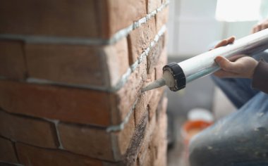 İnşaat işçisinin yakın çekimi, özel silahtan boş tuğla alana tayları yerleştirdi. Yeni ev projesinde tamamlanmamış detaylar. Yenileme, inşa konsepti