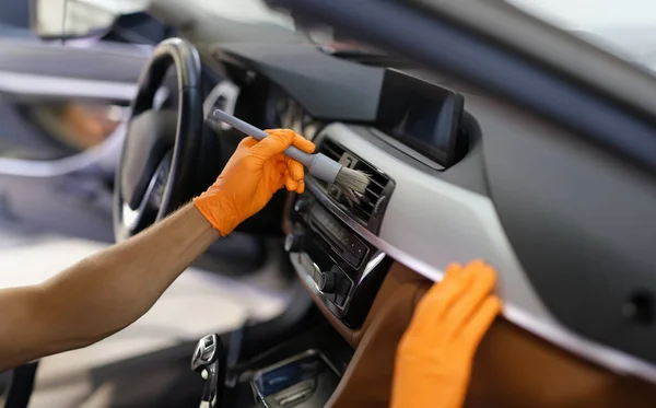 Brush cleaning of dust from car interior parts. Cleaning ventilation in car concept