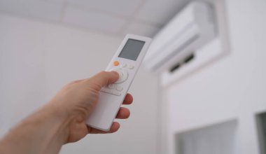 Klimayı uzaktan kumandalı biri tutuyor. Ev konseptinde iklim kontrolü