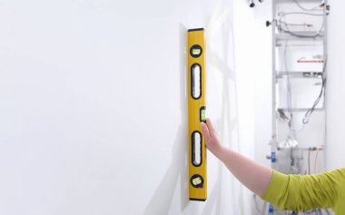 İnşaat seviyesindeki el, duvar ölçer. İnşaatta su seviyesini ölçmek için aygıt