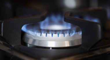Ocakta gaz ocağı var. Yakın çekimde mavi ateş var. Benzin fiyatları düzenlemesi kavramı