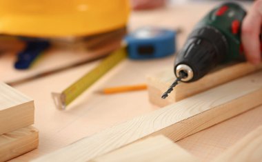 Elektrikli matkap closeup kullanarak alt kollarından. El ile iş DIY ilham iyileştirme iş tamir dükkanı sarı kask sanayi başlangıç fikir endüstriyel eğitim meslek kariyer kavramı