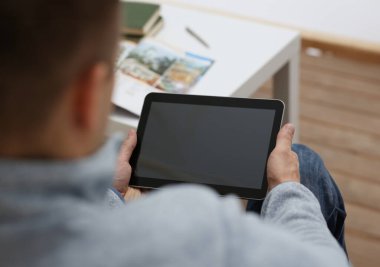 Kanepede oturan ekran boş zaman listering müzik kavramı portre üzerinde bir parmak basmak için uygulama kullanma enterne dalga köpüğü nişanlı iken kurulmasında ev tablet pad erkek el tutar.