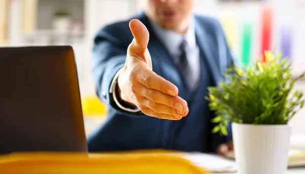Man in suit and tie give hand as hello in office closeup. Friend welcome mediation offer positive introduction thanks gesture summit participate approval motivation male arm strike bargain