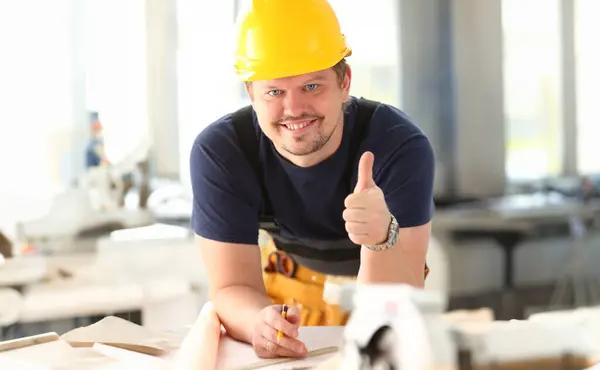 Smiling worker in yellow helmet show confirm sign with thumb up at arm portrait. Manual job DIY inspiration joinery startup idea fix shop hard hat industrial education profession career concept