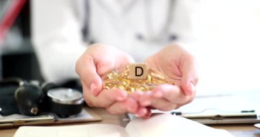 D vitamini tabletini elinde tutan bir doktor. Biyolojik gıda takviyeleri ve vitaminlerle tedavi
