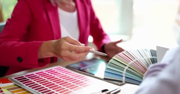 男人和女人在商店里讨论新的油漆颜色 比较一套彩色卡片上的色调 从彩色调色板中选择颜色 — 图库视频影像