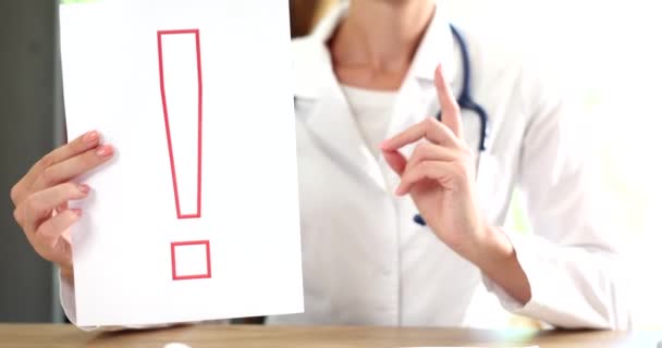 医者は親指を立てて赤い感嘆符を掲げている 注意と健康予防 — ストック動画