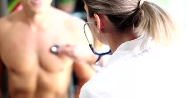 Врач Держит Стетоскоп Груди Спортсмена Проверка Здоровья Легких Сердца Пациента — стоковое видео
