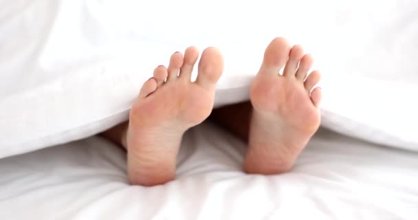 Κοντινό Πλάνο Γυναικείων Ποδιών Κάτω Από Λευκή Κουβέρτα Στο Κρεβάτι — Αρχείο Βίντεο