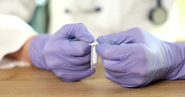 Lastik eldivenli doktorlar rektal fitilleri açıyorlar. Jinekolojide iltihap önleyici fitiller