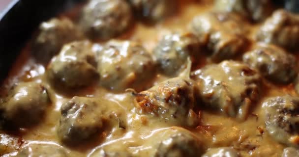 将美味的小肉丸子放入油腻的酱汁中 在煎锅中烹调和翻炒 锅里的肉丸子 — 图库视频影像