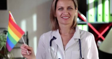 Gökkuşağı bayrağı taşıyan güzel bir kadın doktor. Biseksüel lezbiyen ve transseksüel bakım konsepti