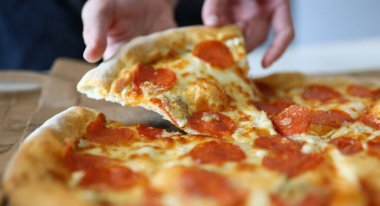Yakın çekim eller sosisli pizzayı alır. Salgın sırasında eve pizza siparişi vermek. Lezzetli geleneksel İtalyan yemeği. Evde fast food var. Kendi etinle güzel bir pizza yap.