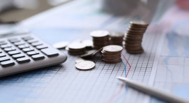 Renk çizelgesinde bozuk paralar ve kalemle hesap makinesi var. İşletmeyi ölçeklendirmek piyasanın ele geçirilmesine yardımcı olur ve kârı etkileyen koşulları dikte eder. Masada grafikler ve çizelgeler var. Müşteri için mali rapor