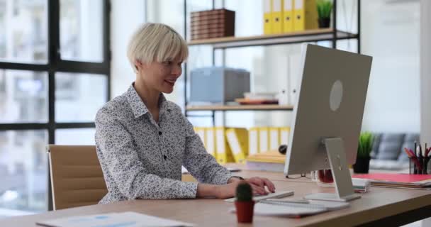 Uśmiechnięta Menadżerka Siedząca Przy Stole Patrząca Ekran Komputera Wpisujący Klawiaturę — Wideo stockowe