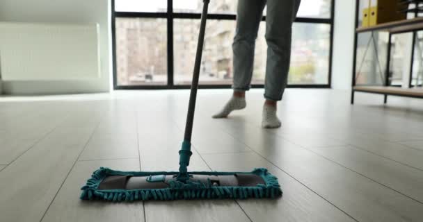 家庭主妇在客厅或办公室用湿湿的拖把擦地板 女人在家里把地板上的泥土清除掉 — 图库视频影像