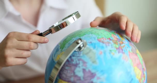 女性観光客は地球と虫眼鏡を保持し 旅行や休暇のための国を選択します 地理学 — ストック動画