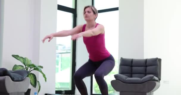 선수인 여자는 웅크리고 앉아서 집에서 운동을 무릎에 통증을 느끼지 않는다 — 비디오