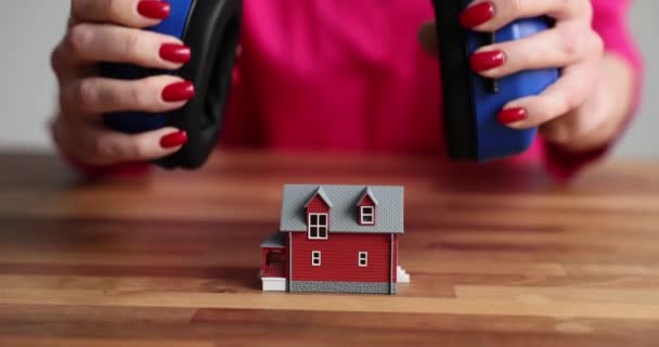 ビルダーのリアクターの手はおもちゃの家に建設ヘッドフォンを置きます 住宅の遮音及び防音 — ストック動画