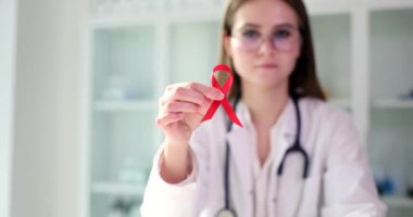 AIDS 'le ilgili kırmızı kurdele Dünya HIV ve AIDS Günü için doktorun elinde. İnsan bağışıklık yetmezliği virüsü ve tedavisi