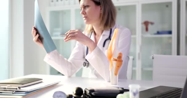 Arzt Untersucht Röntgenbild Knie Und Kniegelenk Modell Der Orthopädischen Abteilung — Stockvideo