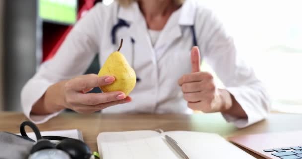 医生营养师拿着黄色的梨子 竖起大拇指 健康食品和维生素饮食的医学概念 — 图库视频影像