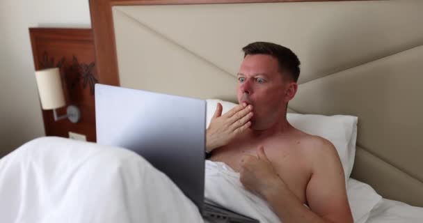 Pria Yang Menggunakan Laptop Berbaring Tempat Tidur Menutup Mulut Dengan — Stok Video