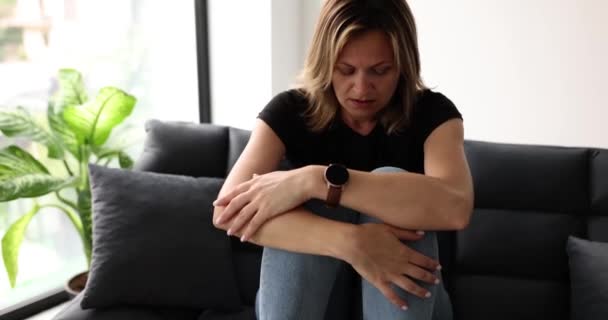 对工作或关系问题感到沮丧的女人坐在沙发上抱着膝盖 女孩感到绝望 孤独和心理问题 — 图库视频影像